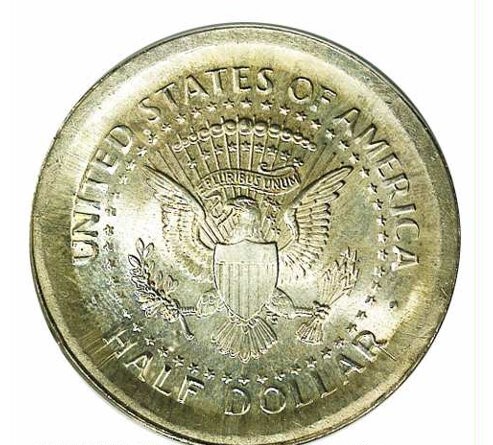 2004 Kennedy half dollar broadstrike error showing enlarged diameter, flattened rims, and smooth plain edge compared to a normal example